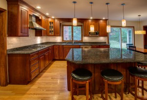 corner newly finished kitchen with granite counter top hardwood cabinet and floor stainless steel fridge