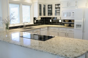 Bright, modern kitchen with black tiles and upscale counter tops.