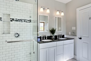 Bright white remodel bathroom. Glass shower and granite counters.